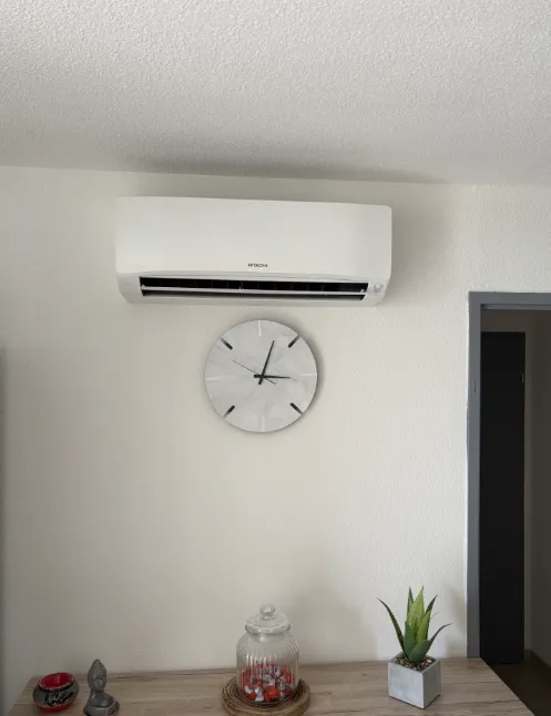 Unité murale Hitachi installée au-dessus d’une horloge dans un intérieur