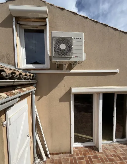Unité extérieure Hitachi fixée sur la façade d’une maison