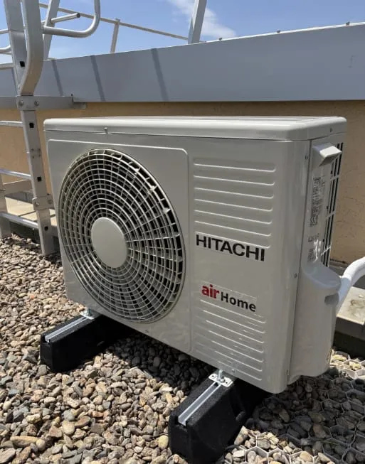 Unité extérieure Hitachi installée sur une toiture plate couverte de graviers