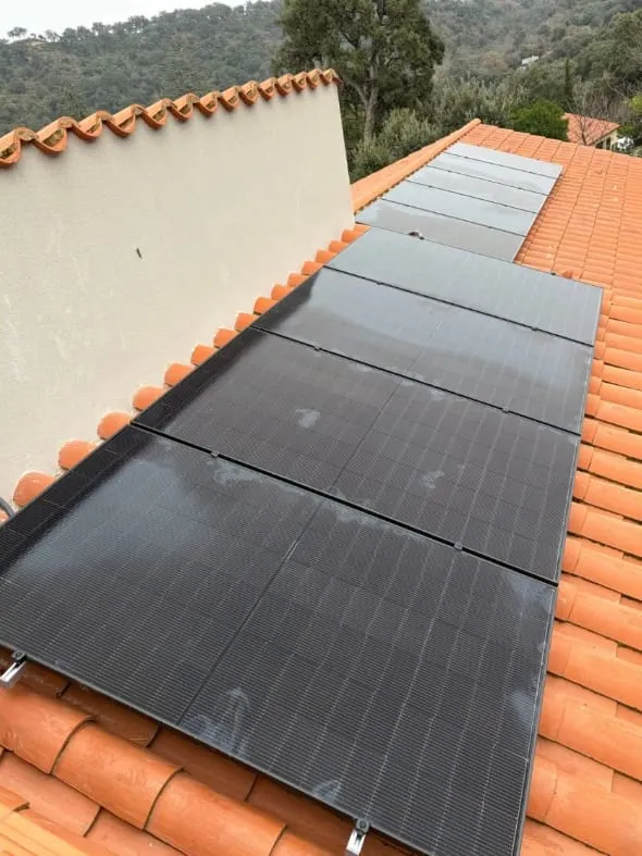 Rangées de panneaux photovoltaïques installées sur les deux pans d’une toiture