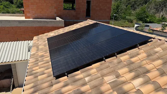 Panneaux photovoltaïques noirs installés sur une toiture en tuiles